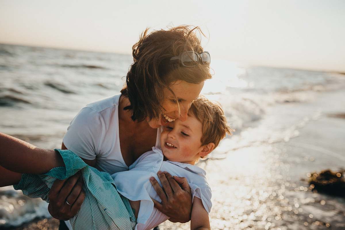 human photo of mother and child beside body of water family