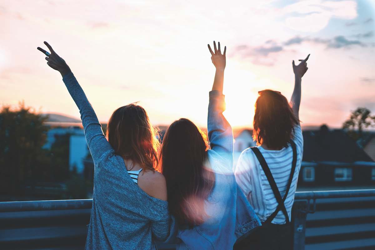 person photo of three women lifting there hands \ friend