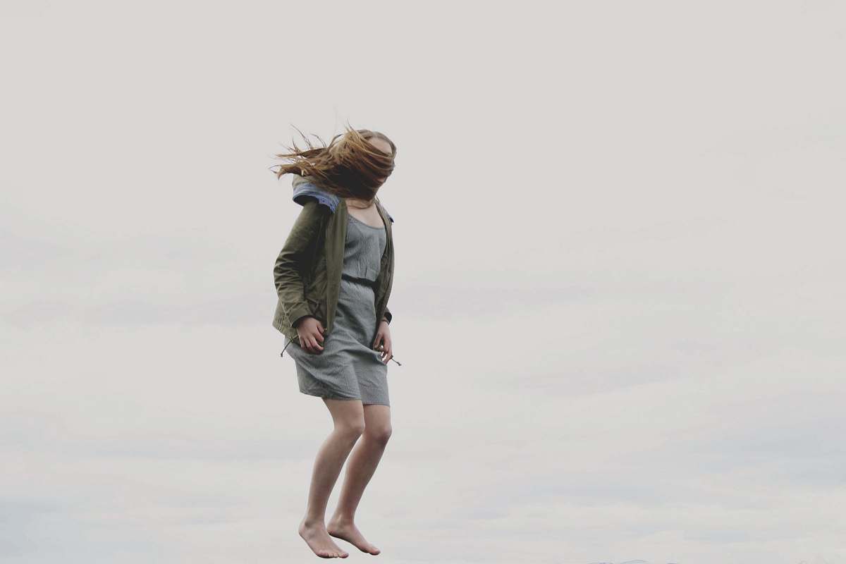 person photography of woman covered with her hair while jumping human