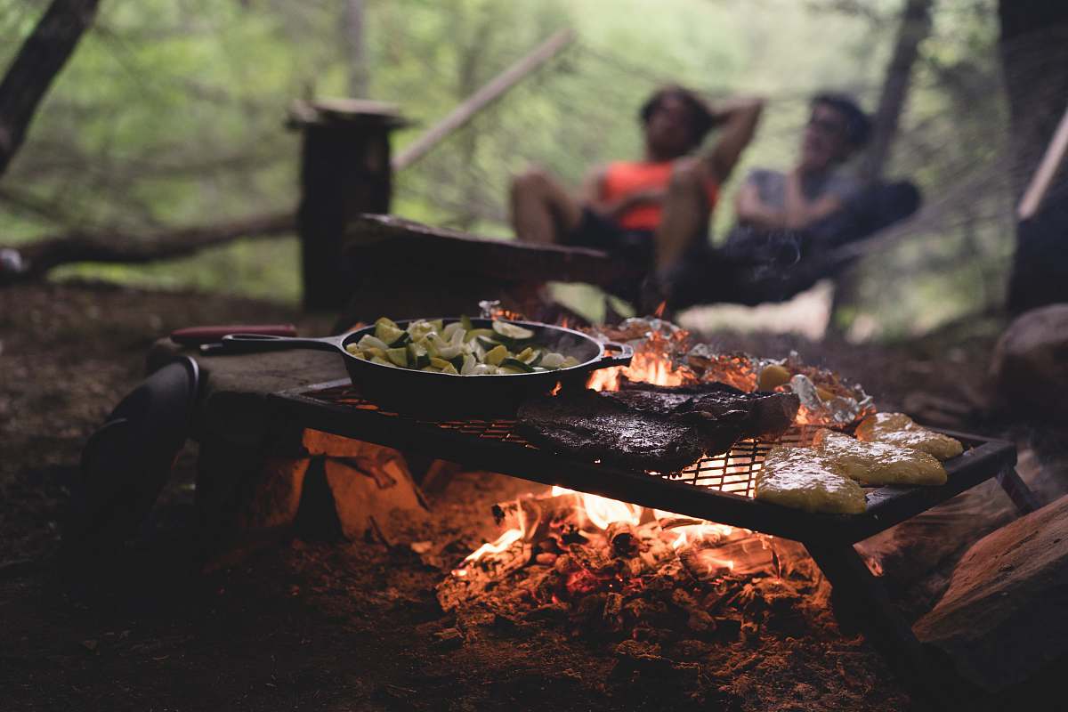 food selective focus photo of skillet and meat on top of grill with fire bbq