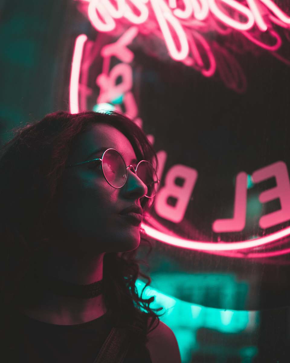 person selective focus photo of woman with neon light signage background neon