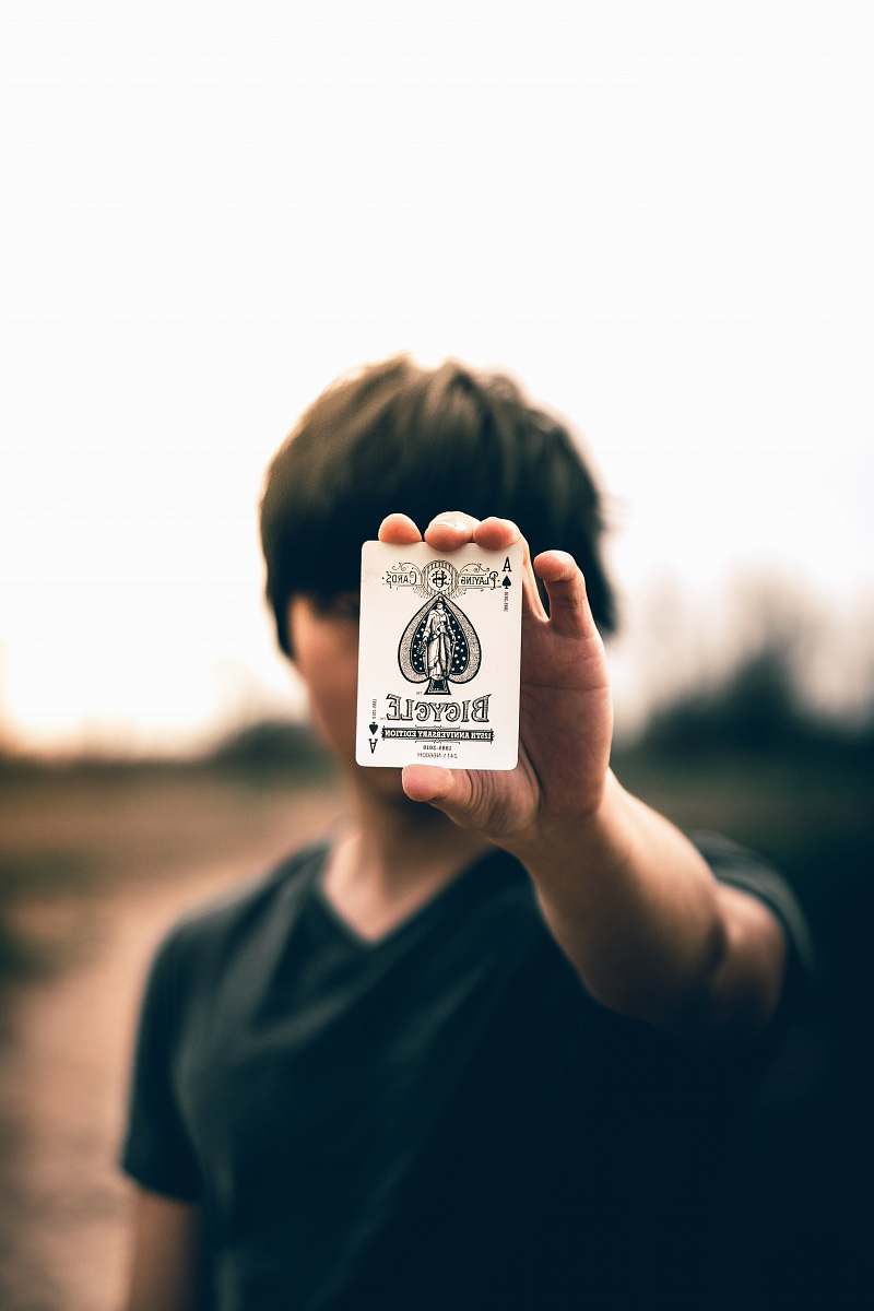person selective focus photography of person holding ace of spades card human