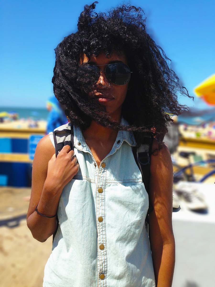 woman selective focus photography of person standing on seashore hair