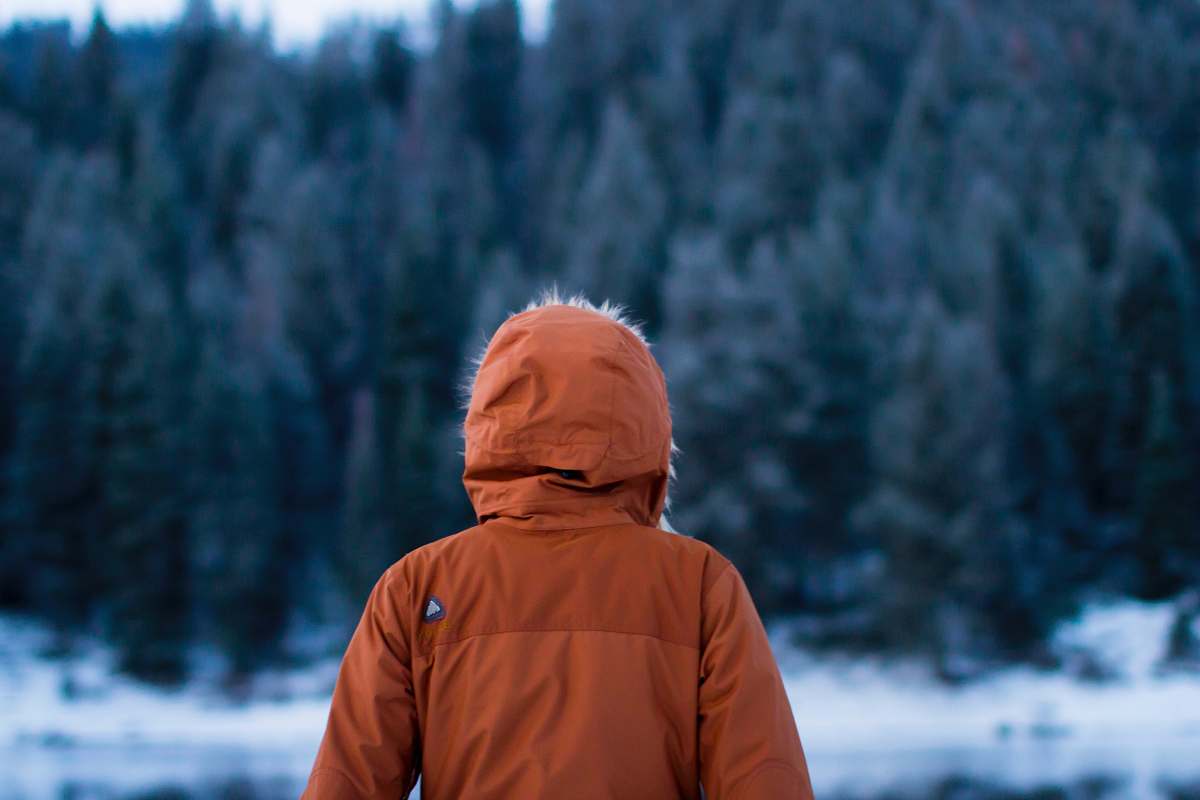 person shallow focus photography of person facing trees cold