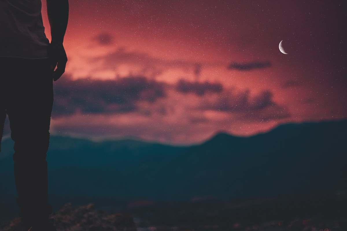 person silhouette of man looking at moon sky