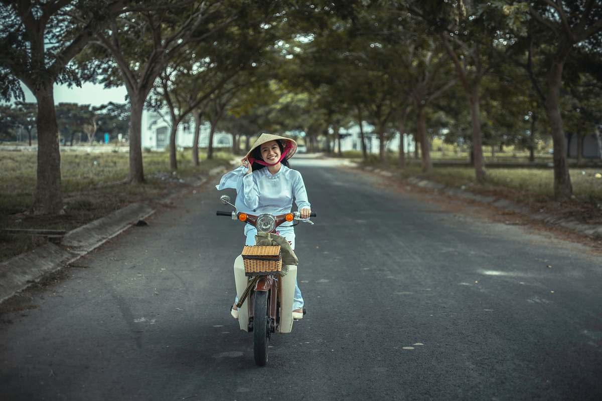 person smiling woman riding scooter on road riding