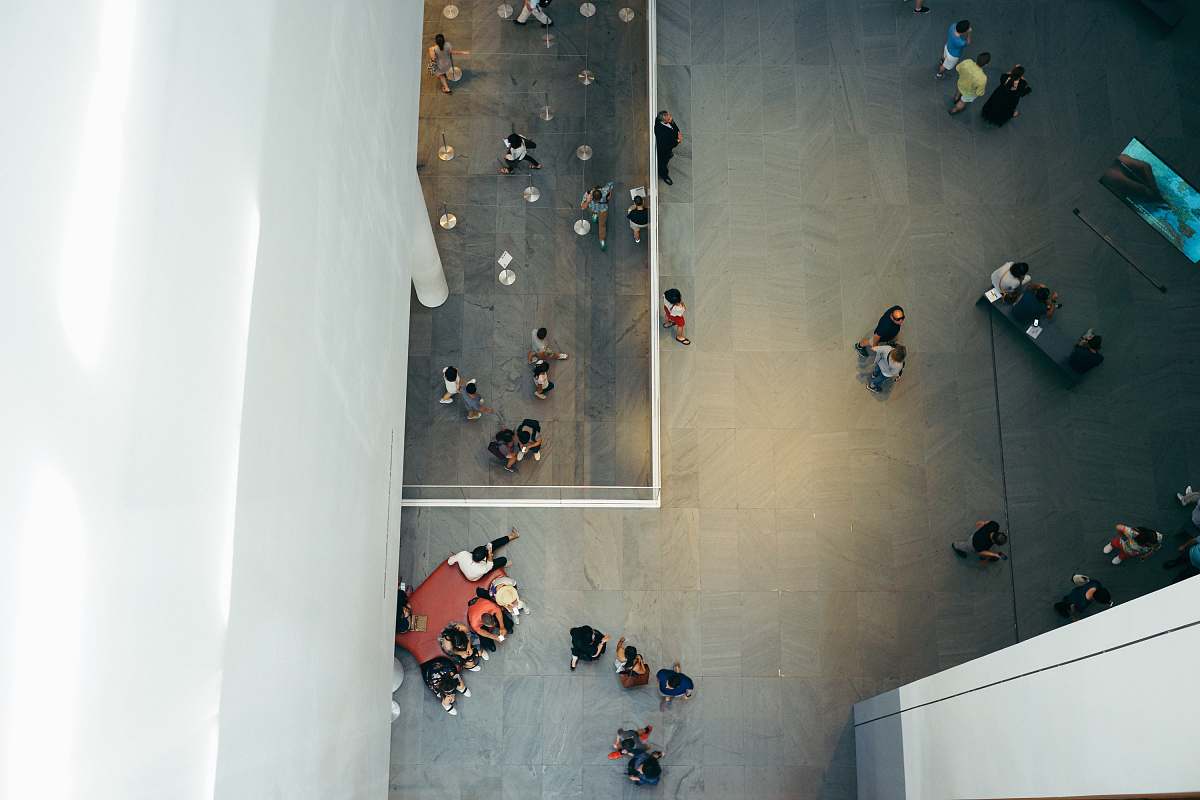 sit top-view photography of people beside white concrete building aerial