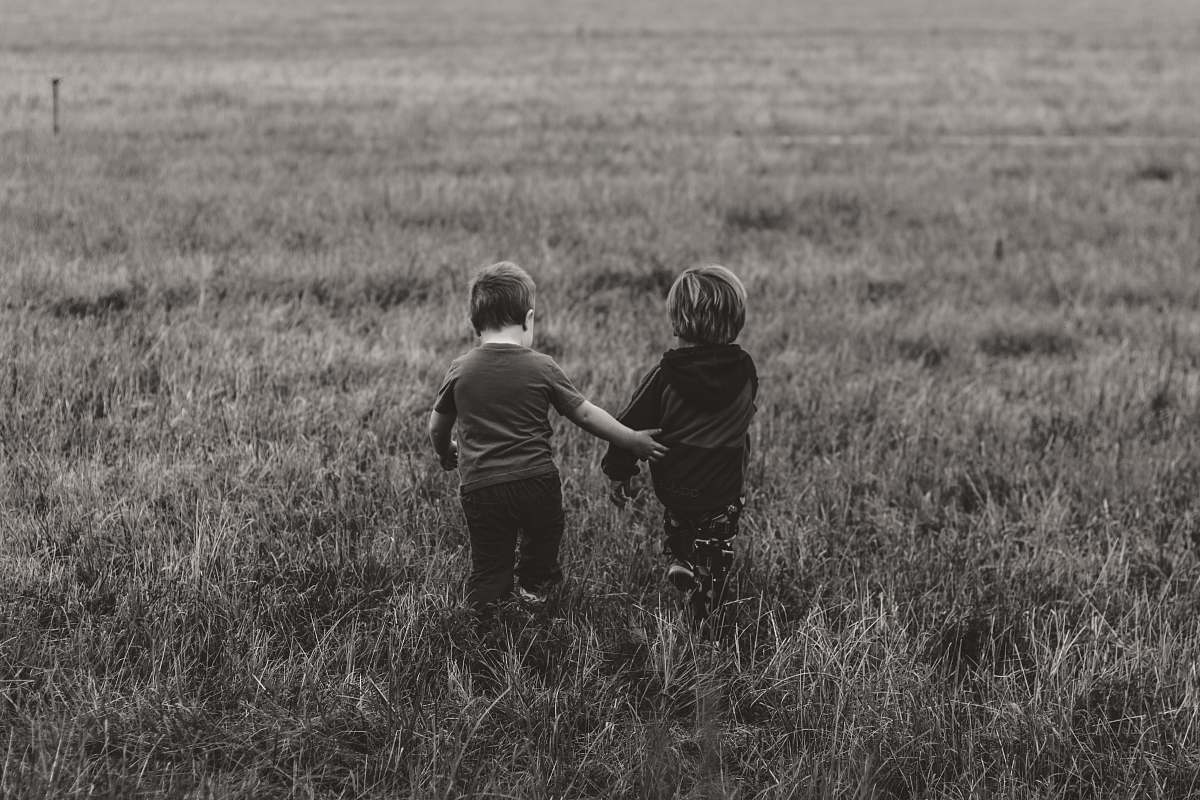 human two boy's walking on green grass field kid