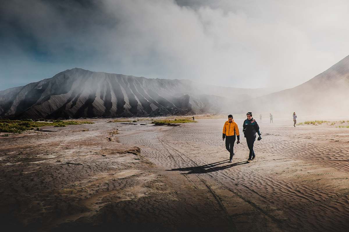 human two person standing on brown sands walking
