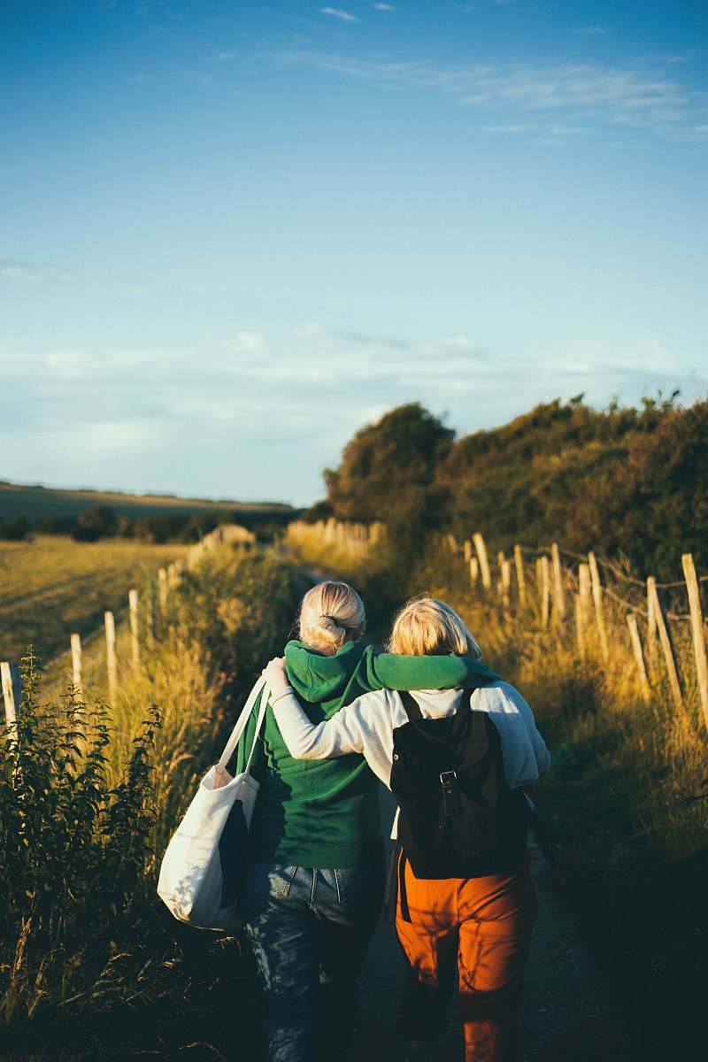 person two women walking together outdoor during daytime human