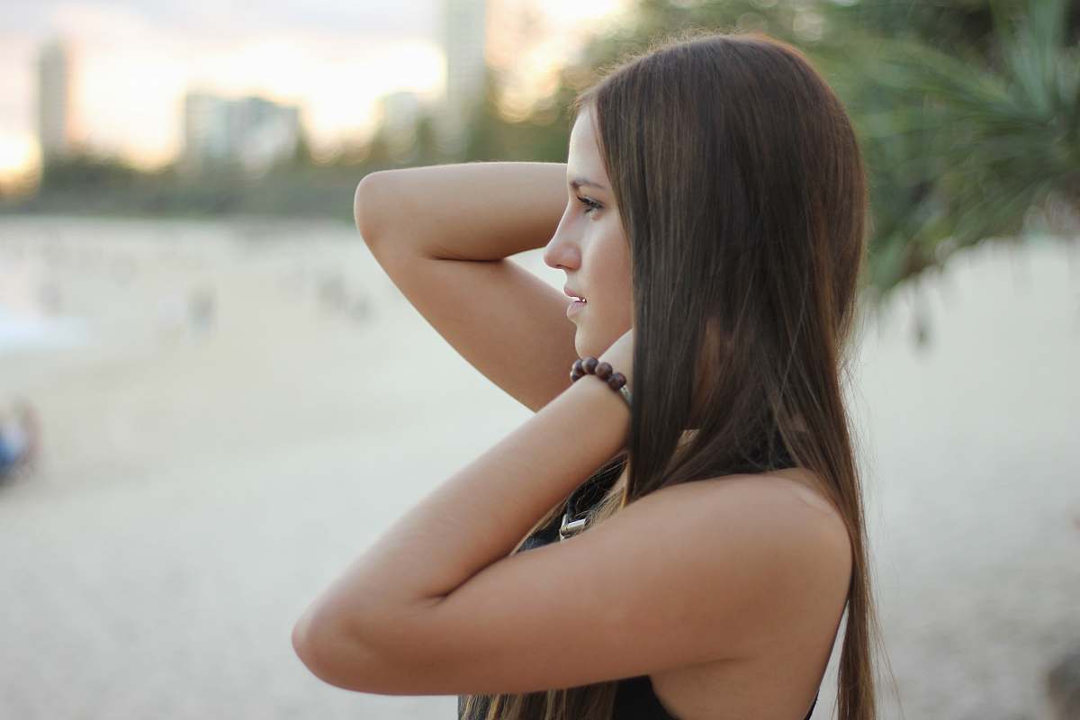 woman woman at the beach facing the ocean during day girl