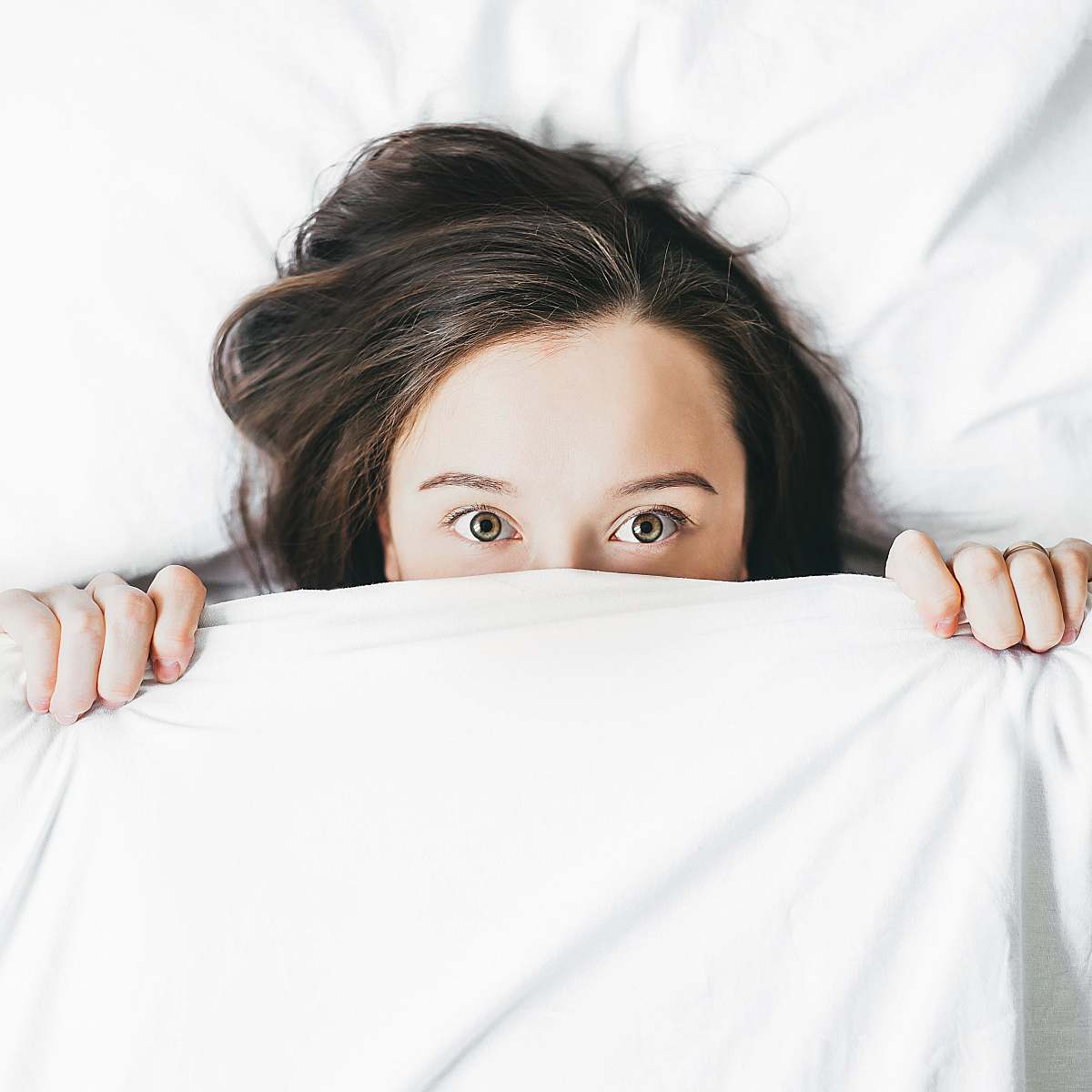 person woman covering her face with blanket sleep