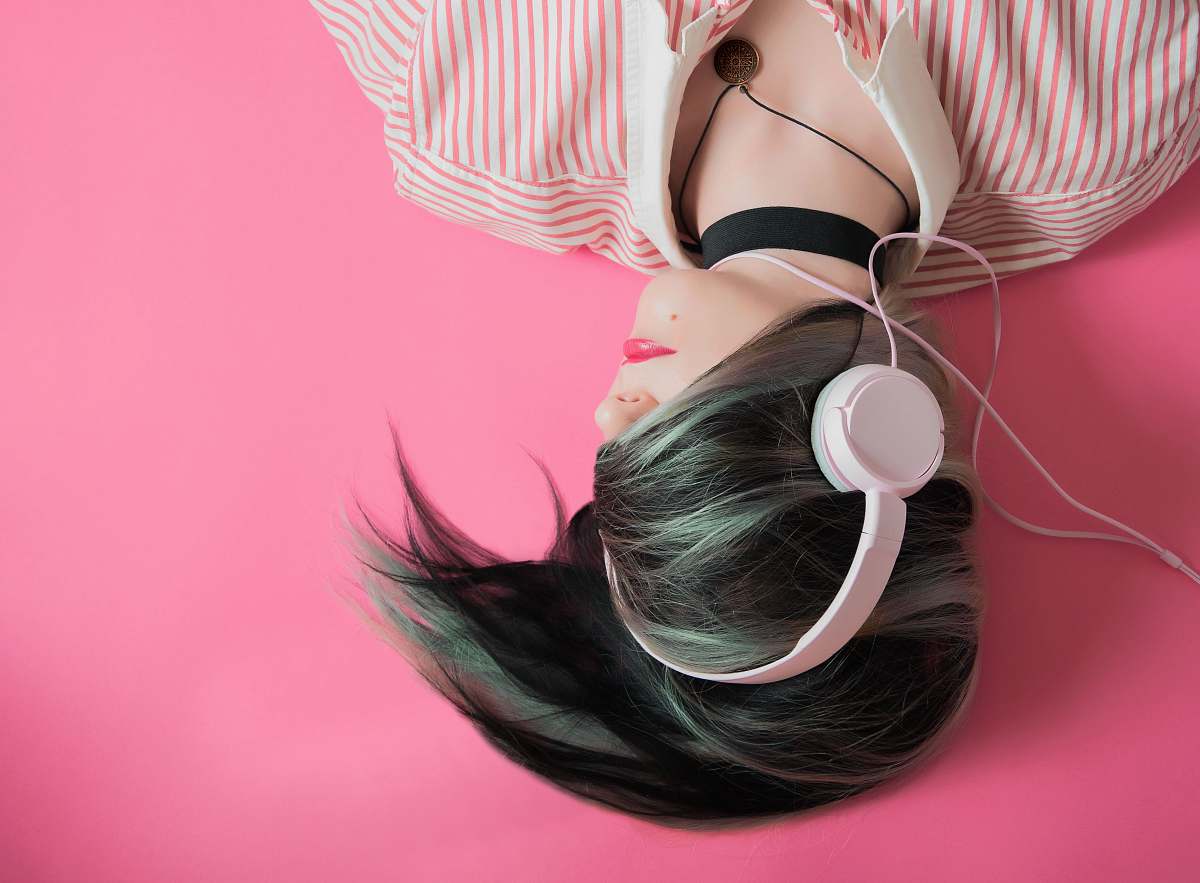 pink woman covering her hair and wearing headphones girl