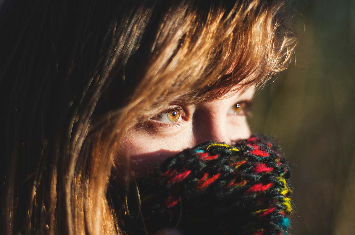person woman covering her multicolored knit mask human