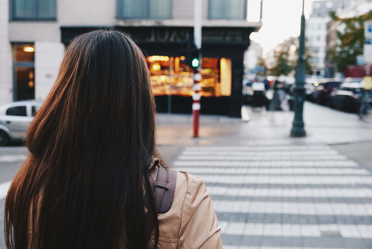 person woman crossing street road