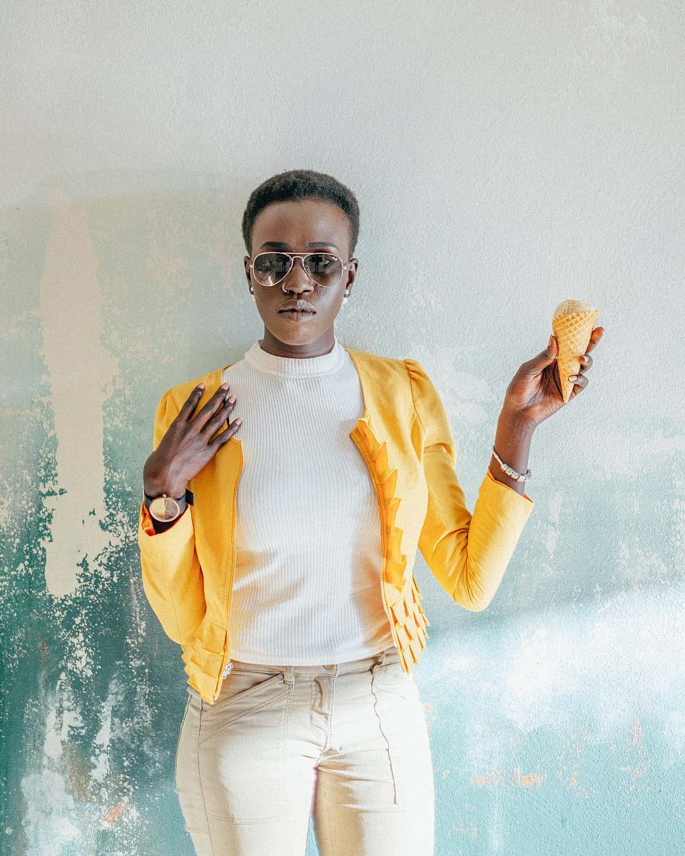 person woman holding ice cream cone taking photo over green wall human