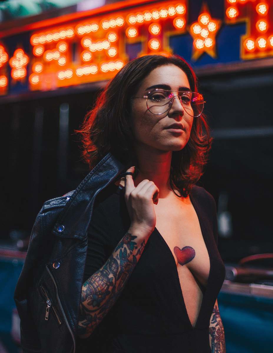 person woman in black plunging-neckline holding black leather jacket photo human