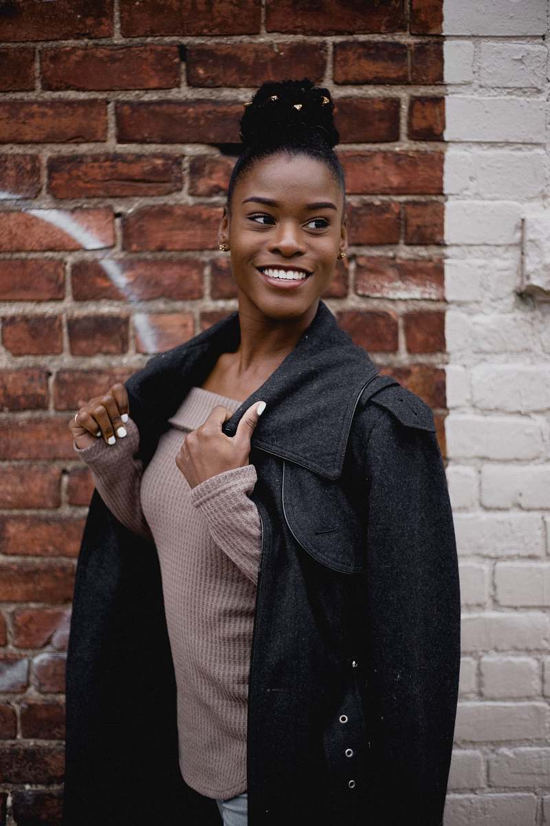human woman in brown tube top under black jacket person