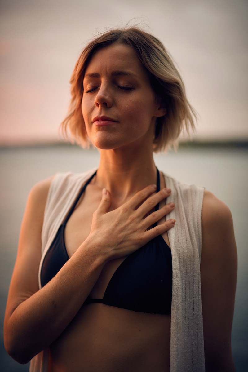 person woman in white vest and black bikini with hand on chest human