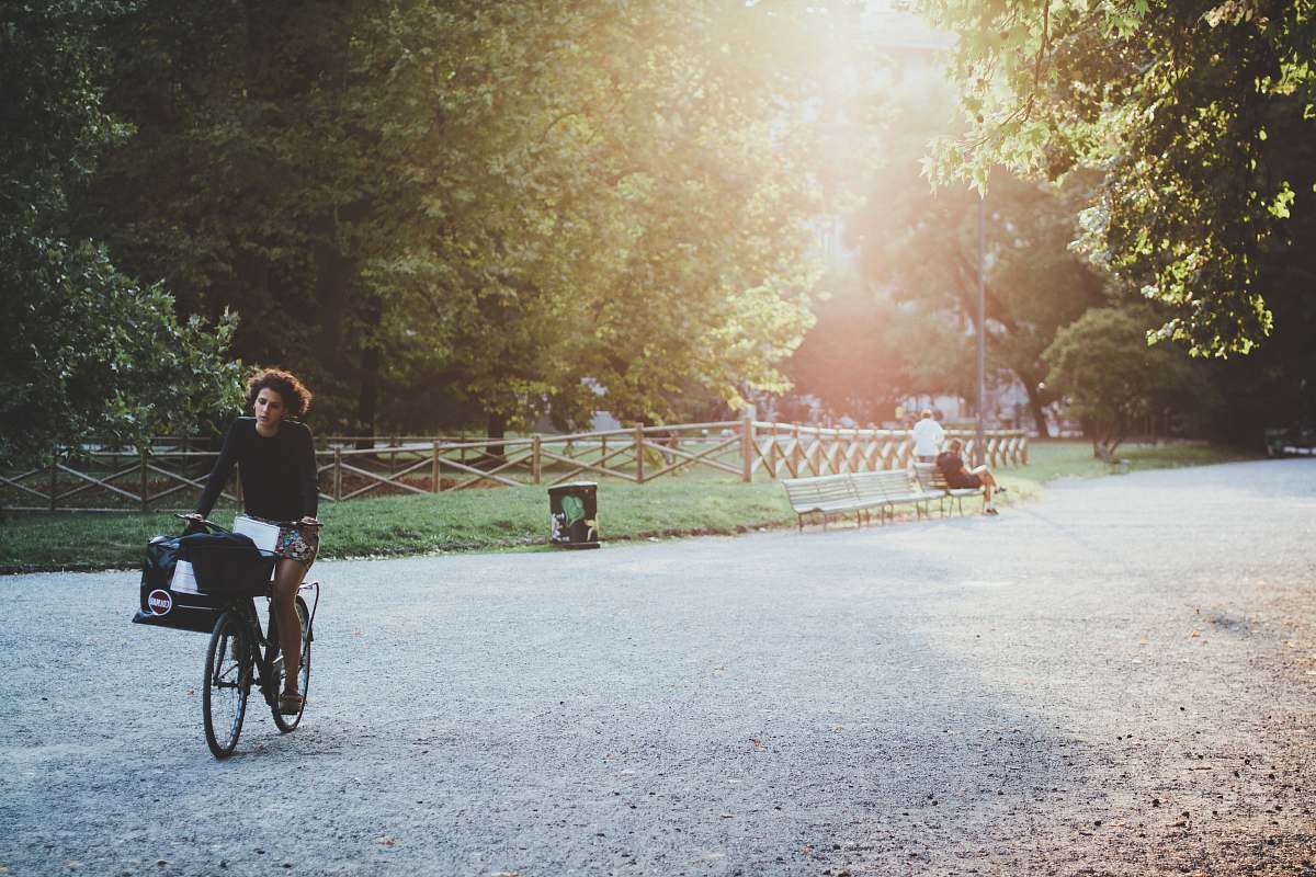 person woman riding bicycle on park during daytime bicycle