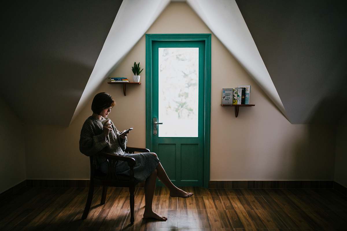 person woman sitting on a chair inside white painted room human