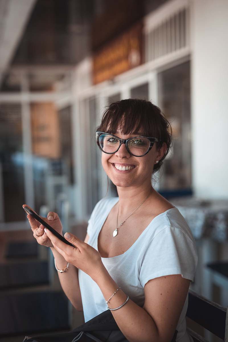 person woman sitting on chair holding phone human