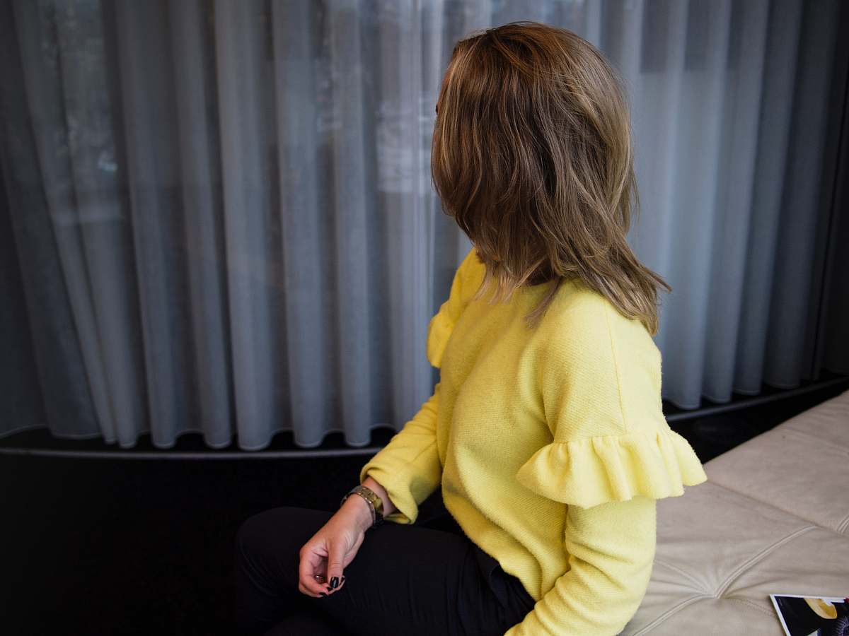 person woman sitting on leather cushion beside glass window human