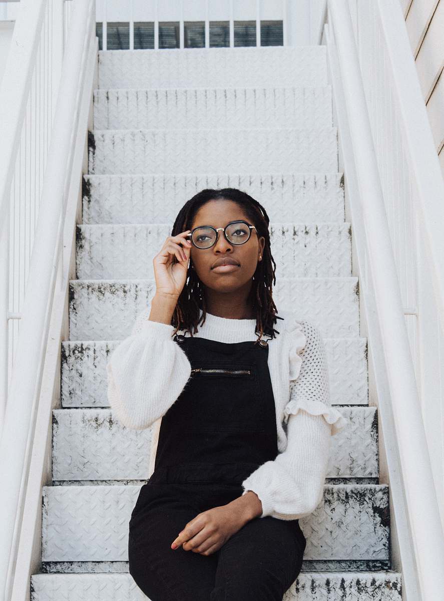 human woman sitting on stair and holding her eyeglasses person