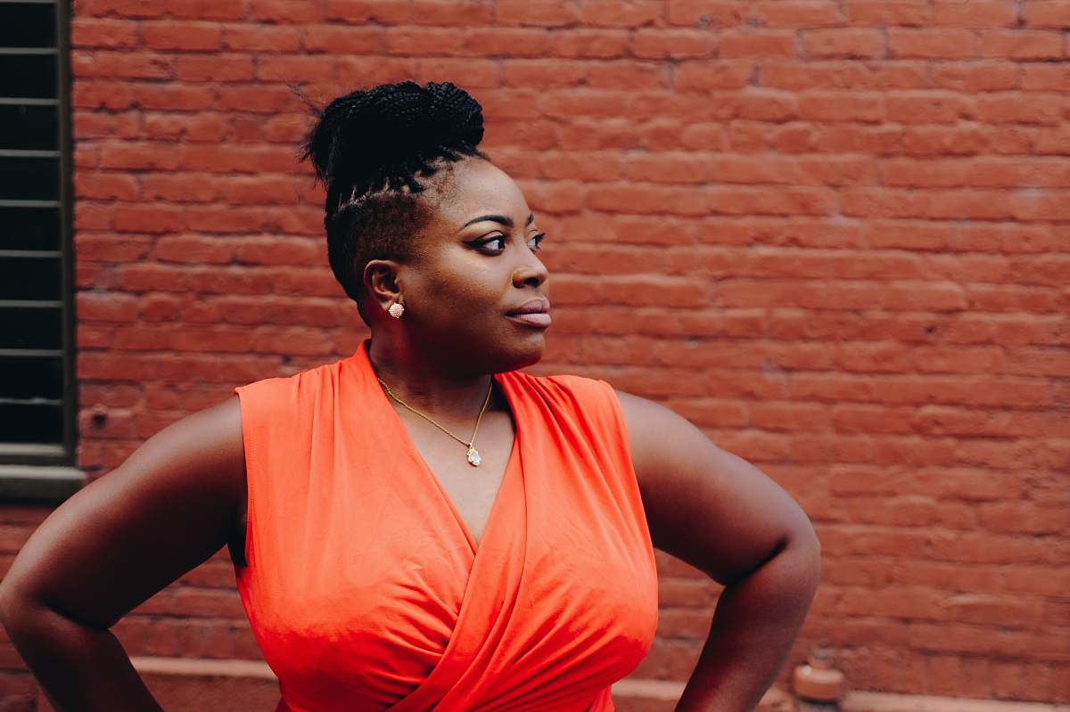 human woman standing in front of red brick wall woman