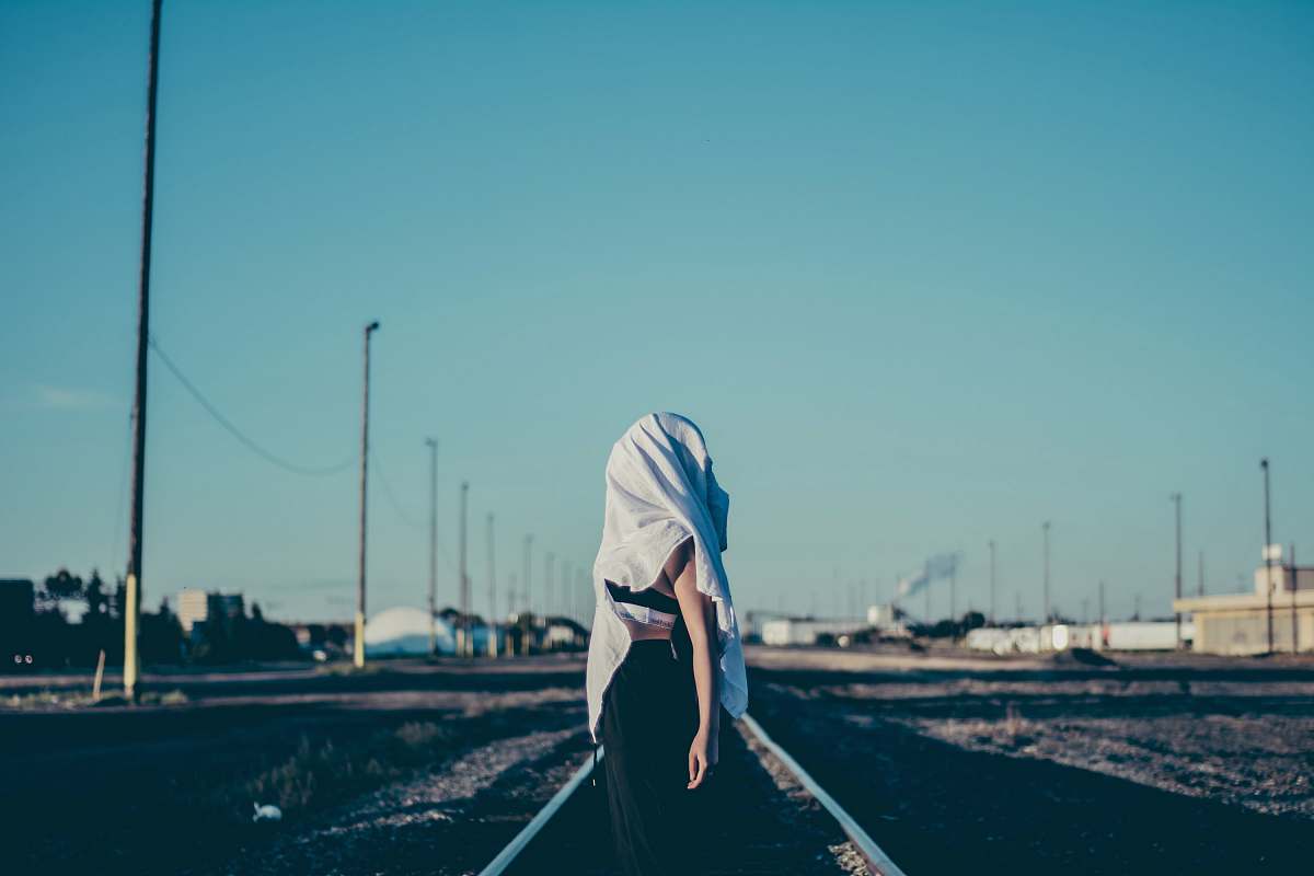person woman standing in the middle of train rail human