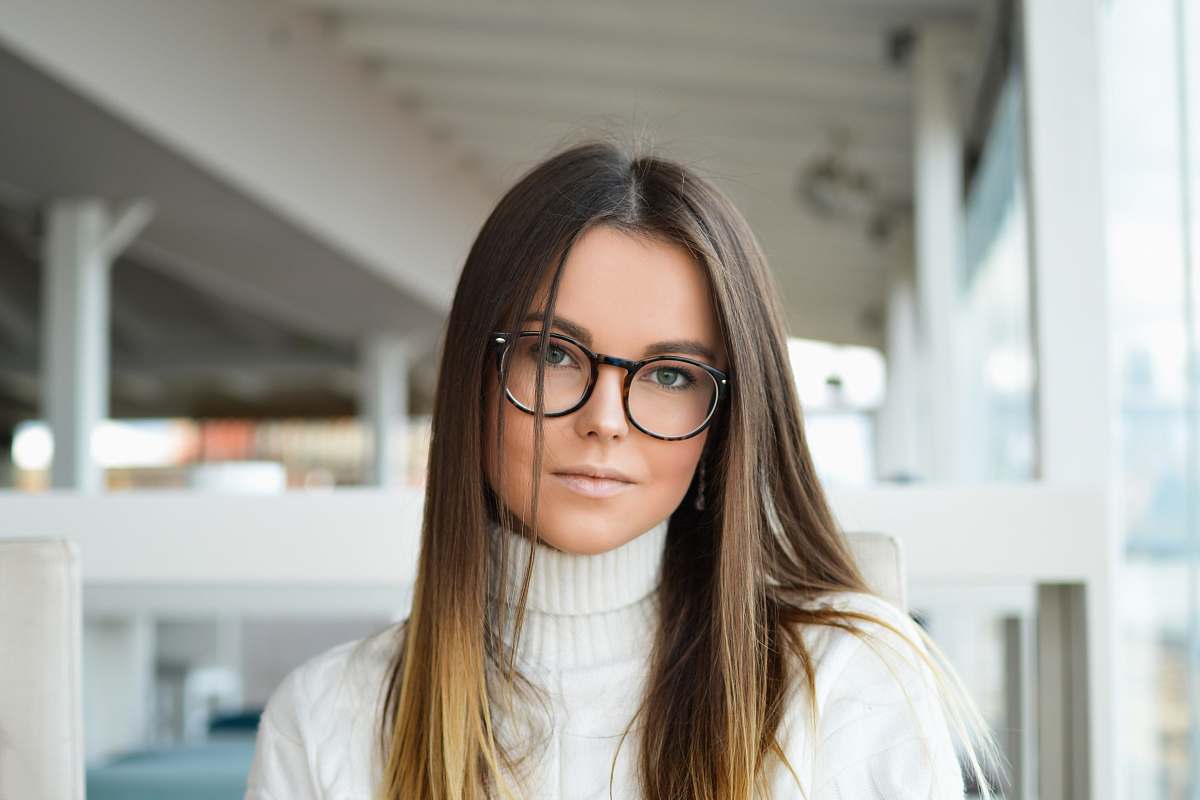 human woman standing near glass window glasses
