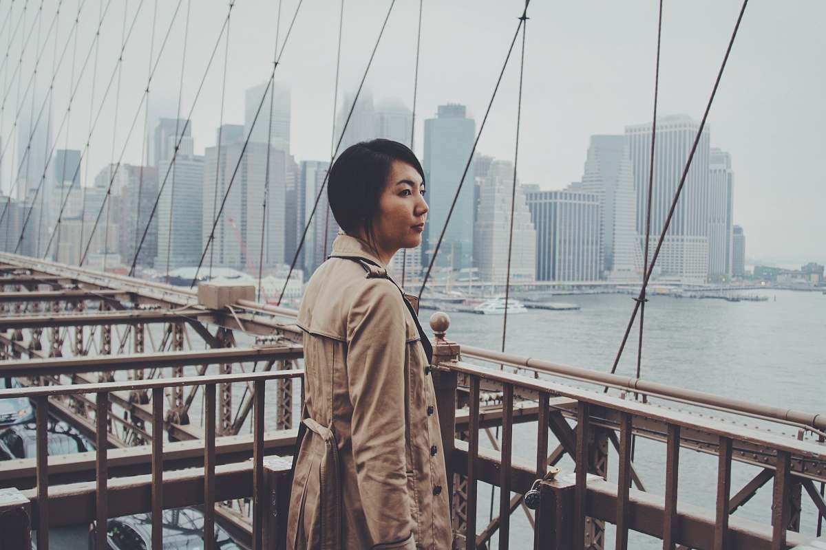 person woman standing on bridge railings at daytime new york