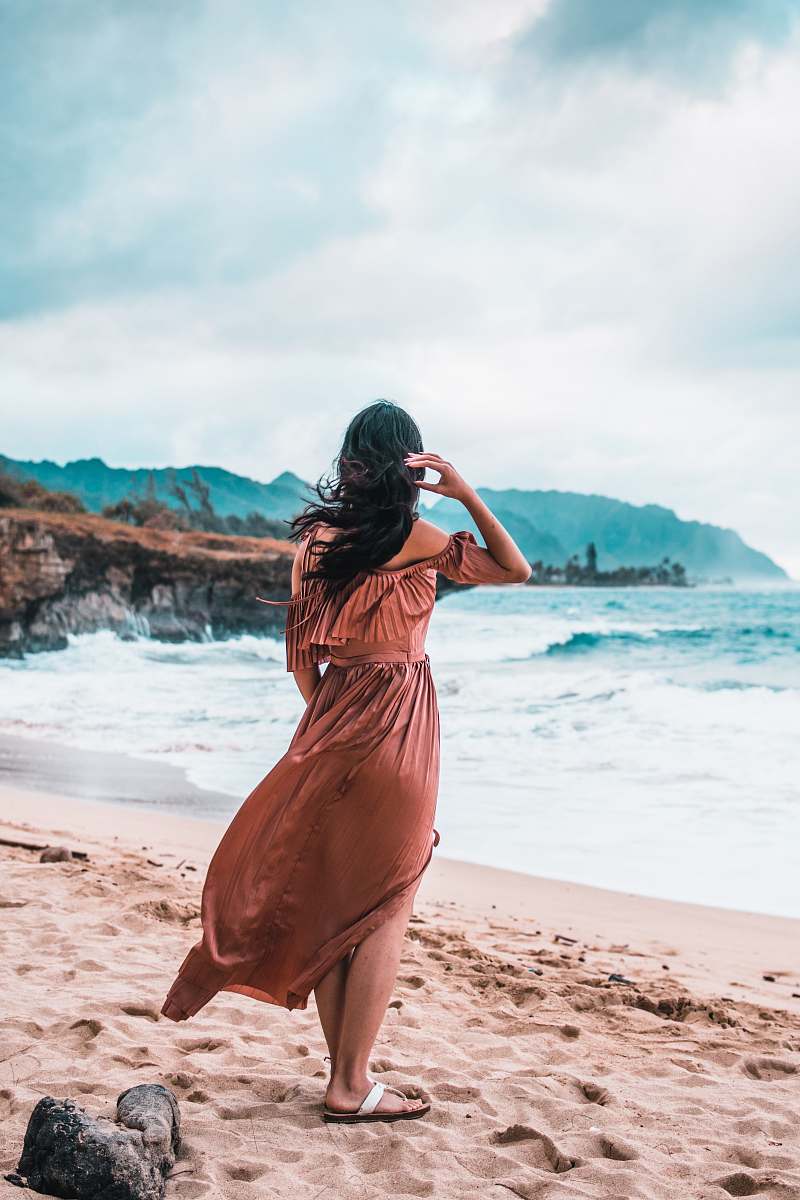 person woman standing on brown sand sand