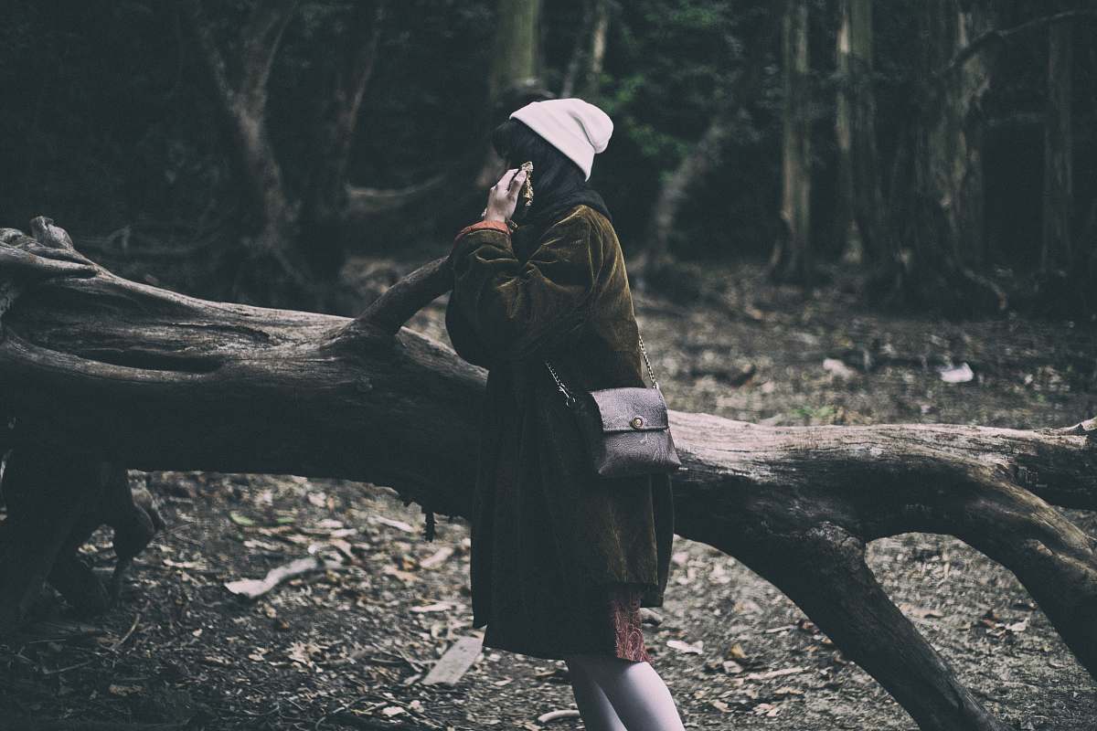 person woman standing on tree part during daytime beanie