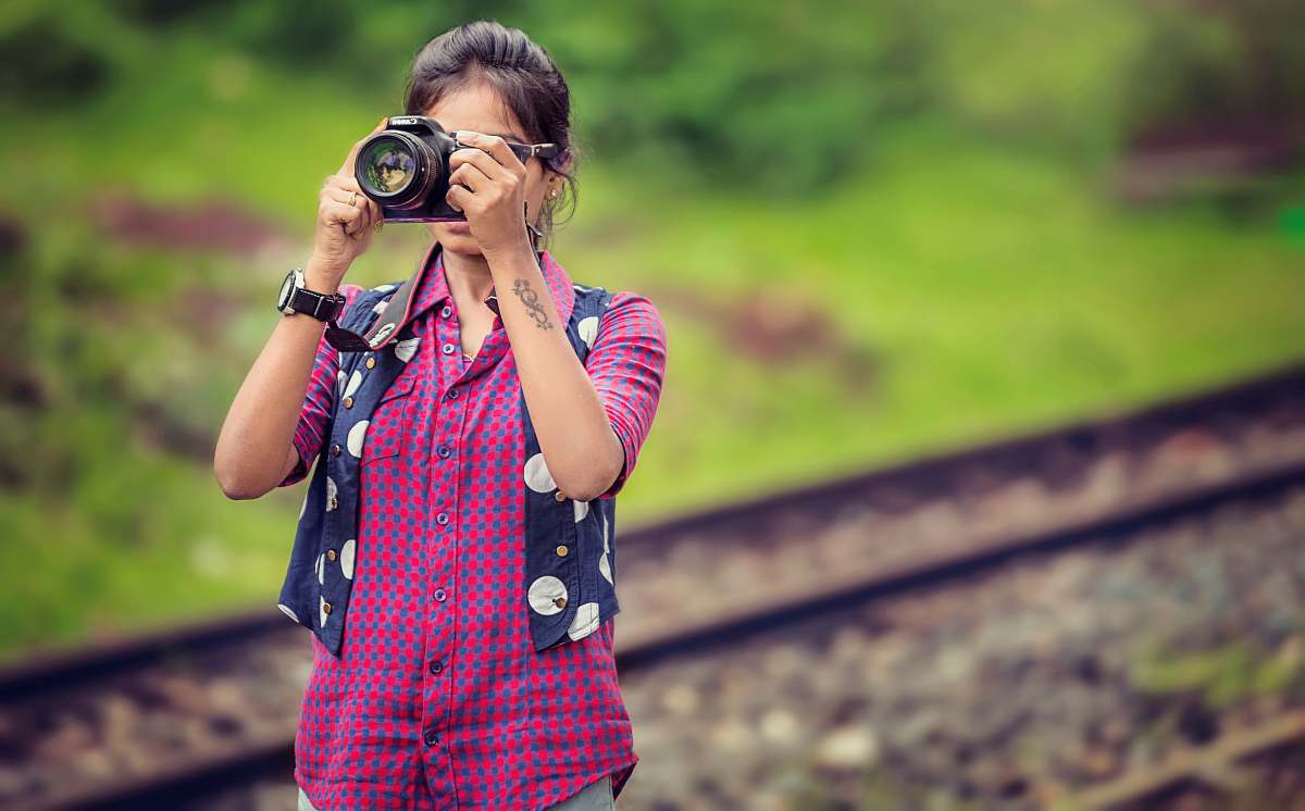 person woman taking photo in selective focus photography human