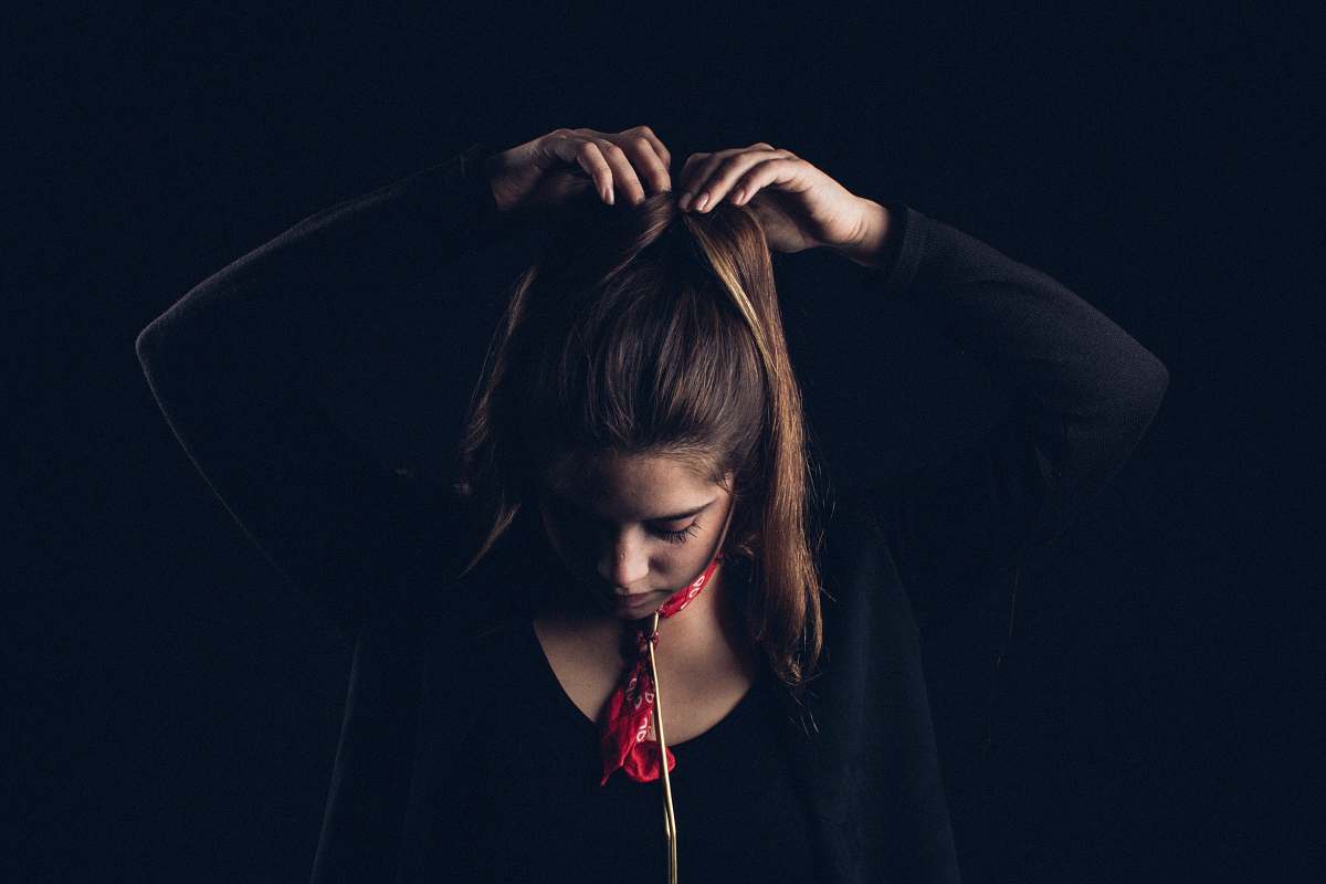 human woman tying hair with both hands person