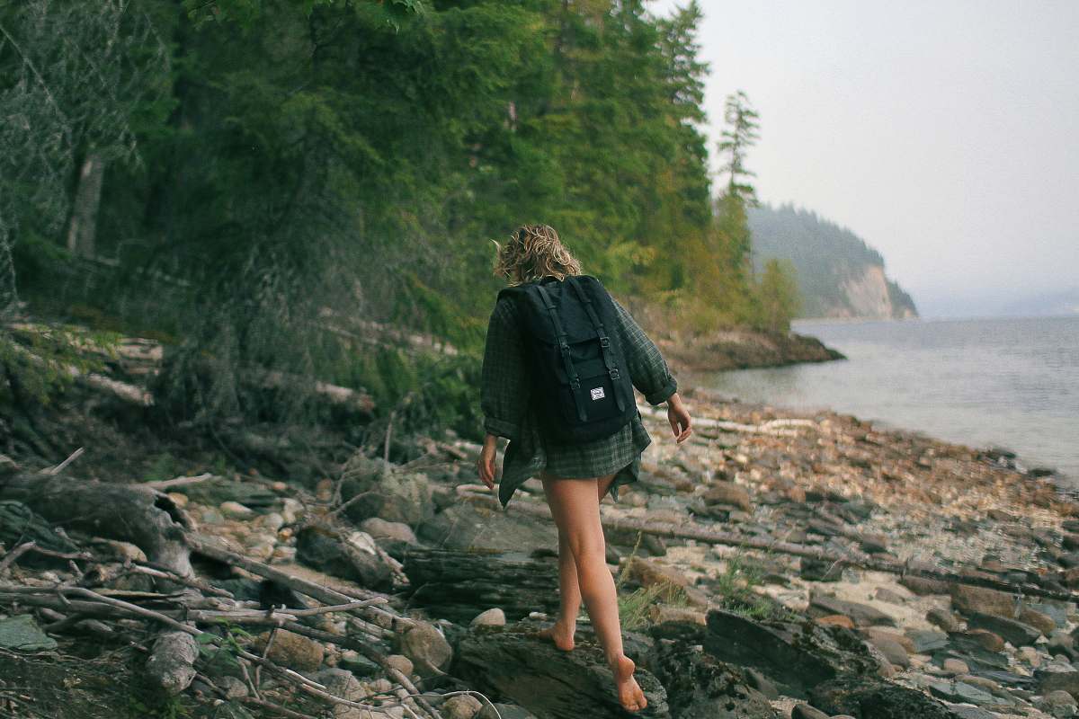human woman walking on rocky seashore person