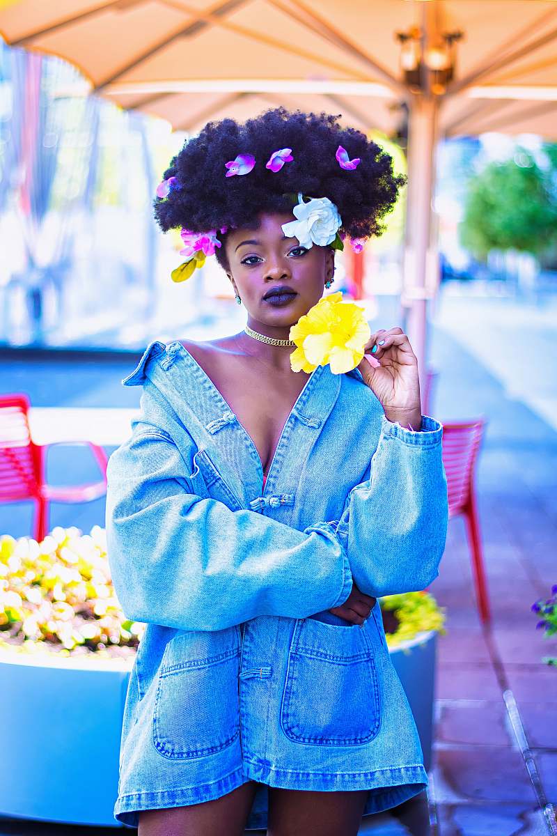 human woman wearing blue denim jacket with flowers on hair person