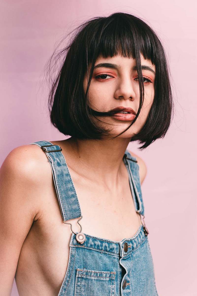 person woman wearing blue denim overalls near wall human