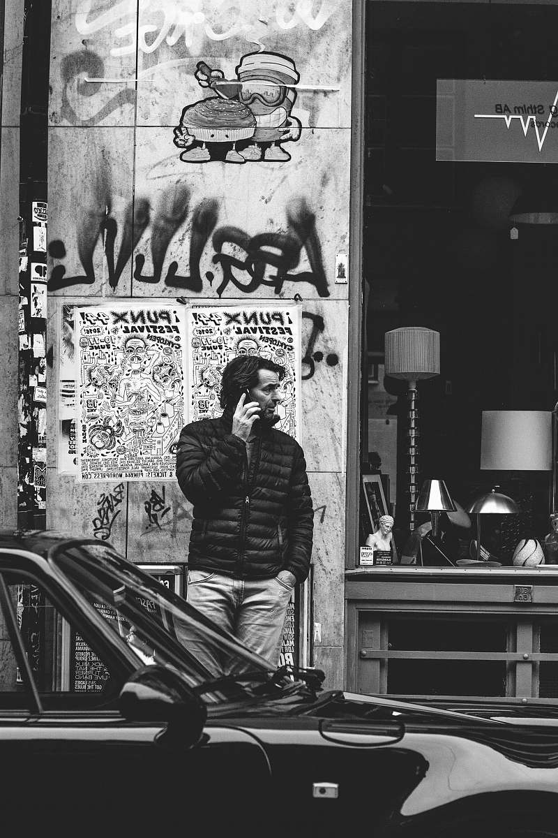 people grayscale photography of man using cellphone black-and-white