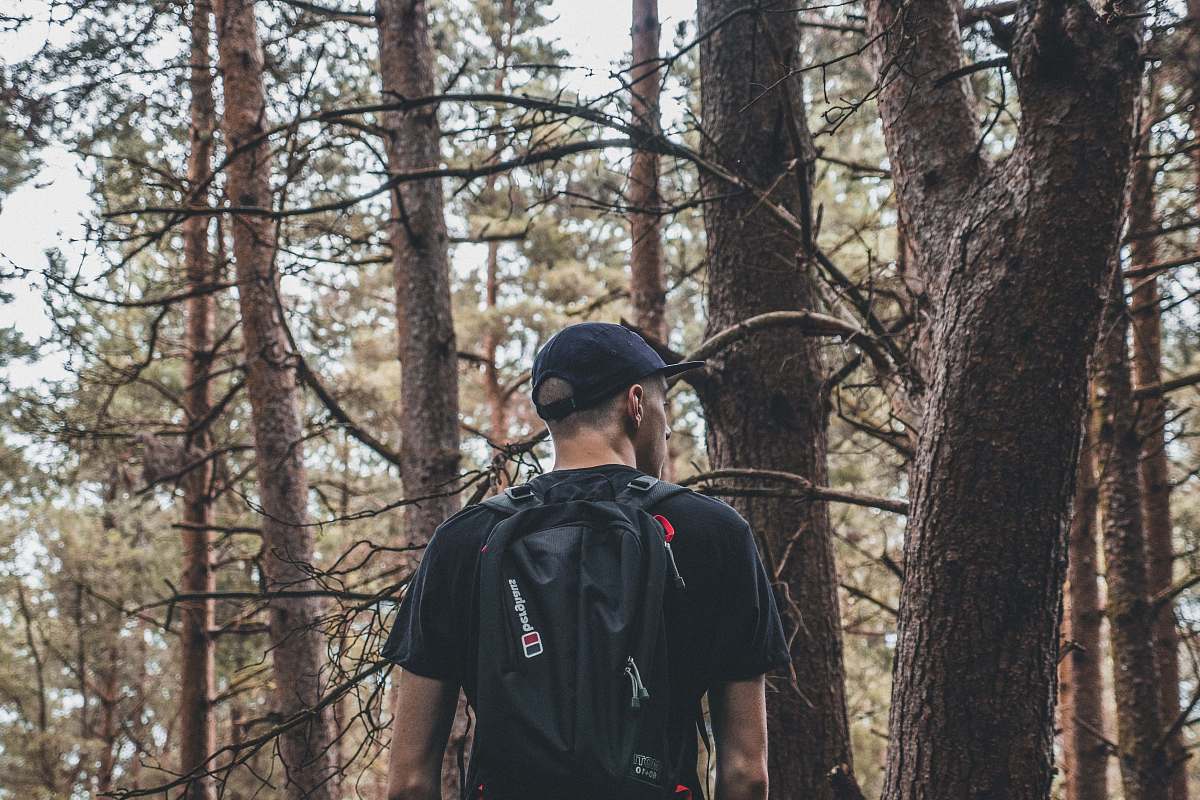 people man carrying black backpack on froest human