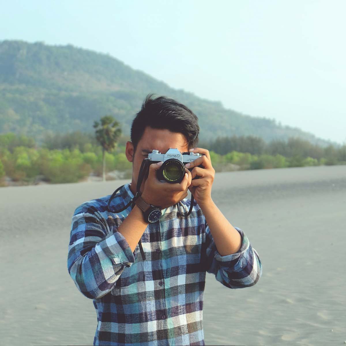 people man holding gray and black camera during daytime human