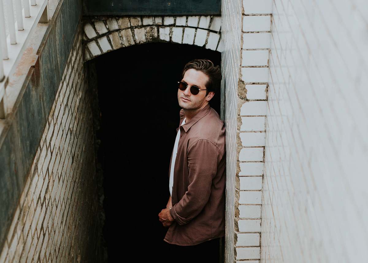 people man leaning on beige wall near hallway human