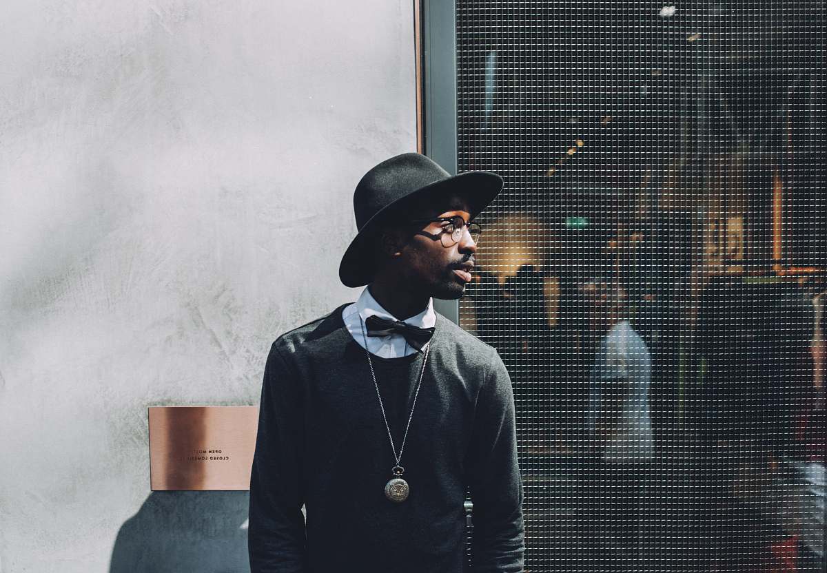people man standing beside metal screen fence fashion