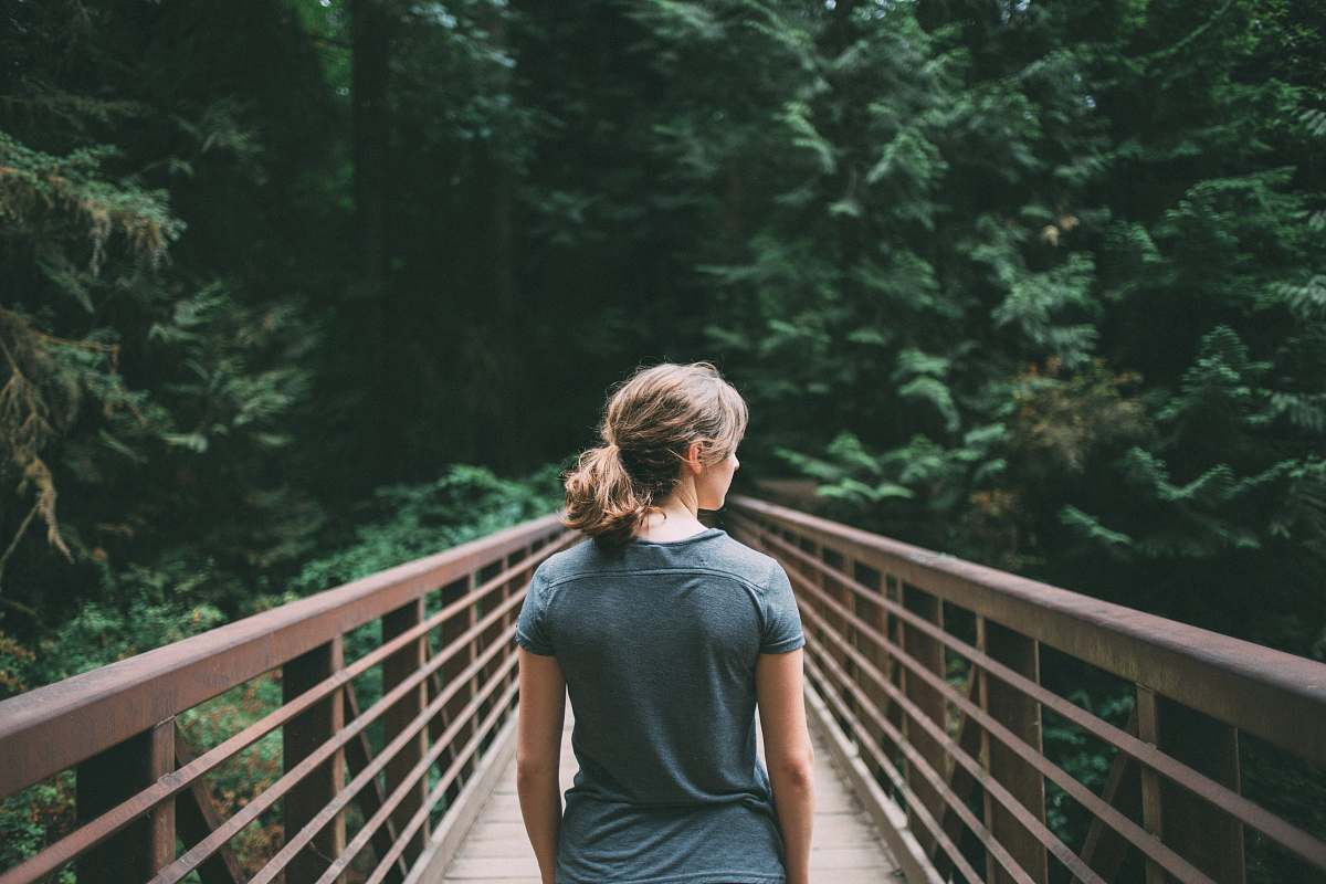 people selective focus photography of woman in black t-shirt standing on bridge woman