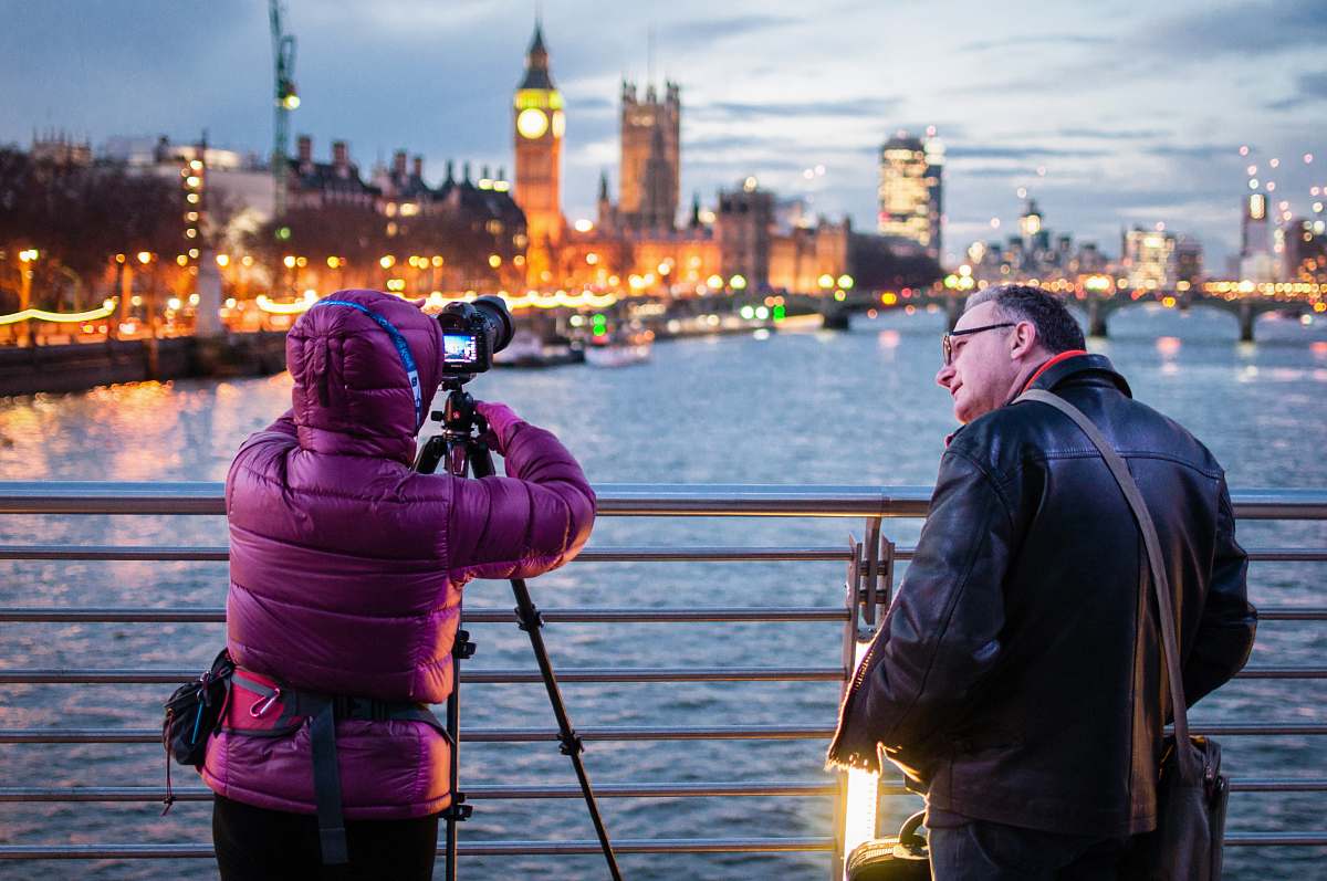 london two people standing in front of silver fence photographer