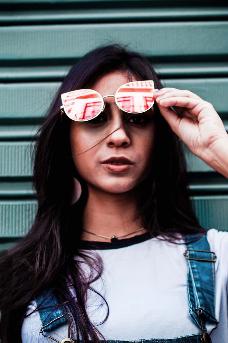 people woman holding sunglasses near gray walpl human