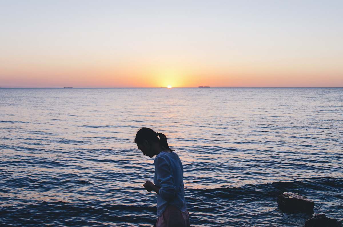people woman in blue long-sleeved shirt near body of water water