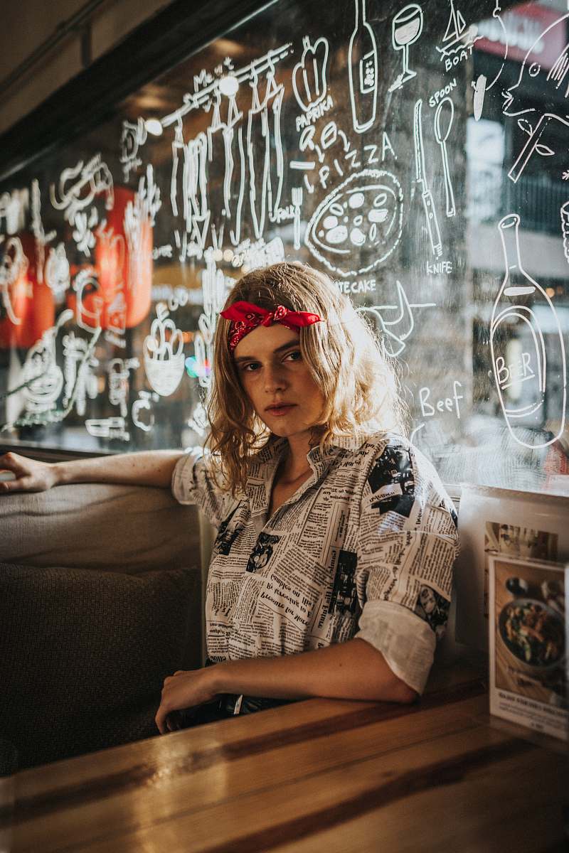 people woman sitting behind graffiti glass wall human