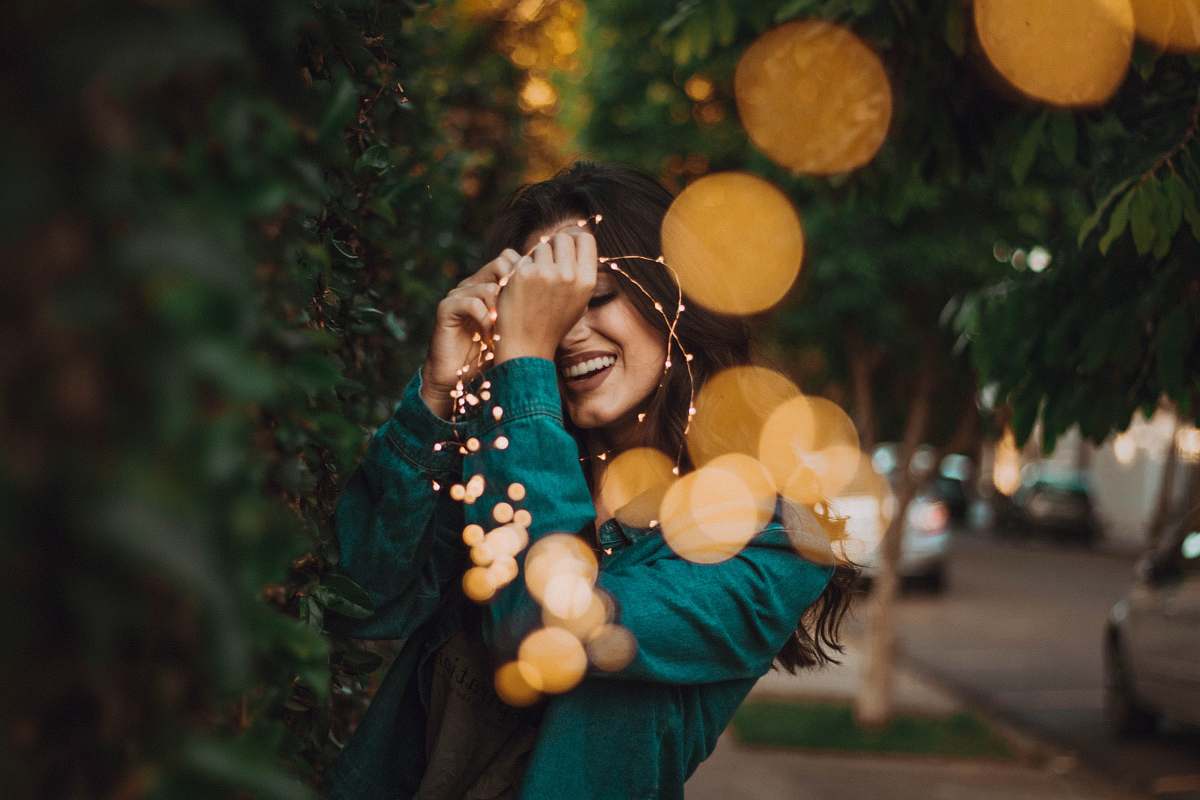 people woman standing in front of green leafed plants with light bokeh human